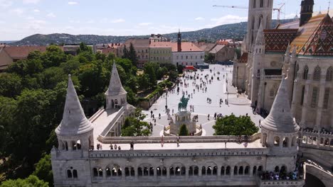 drone flying by fisherman's bastion towards matthias church and historical buildings in buda castle district