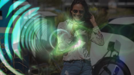 animation of neon glowing tunnel against caucasian woman using smartphone near her car