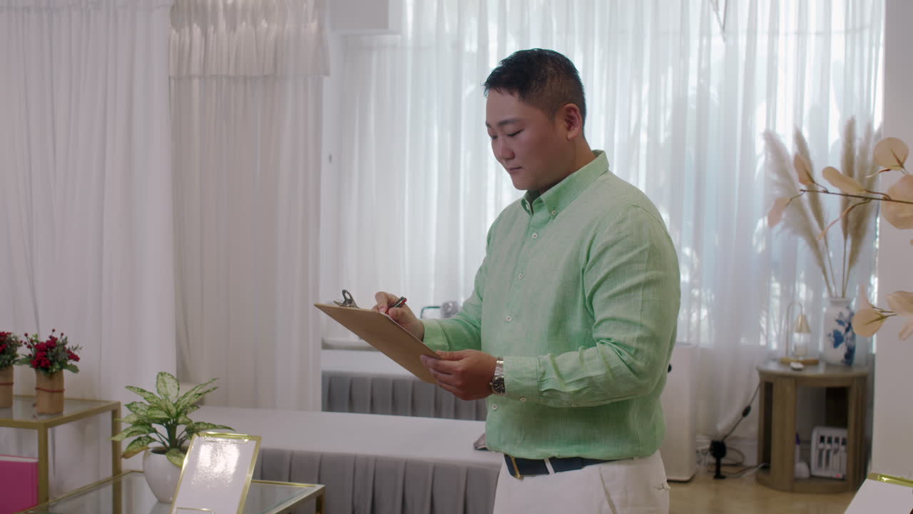 Portrait of Cheerful Asian Spa Salon Manager Holding Folder
