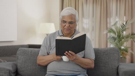 Indian-old-man-drinking-tea-and-reading-book