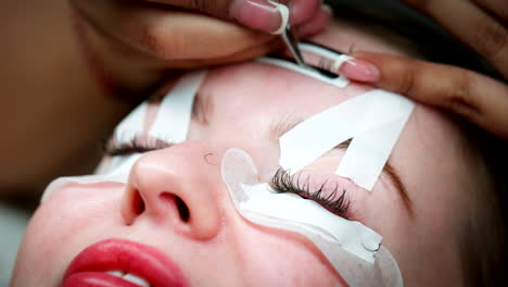 closeup on face of caucasian woman getting lash extensions beauty treatment