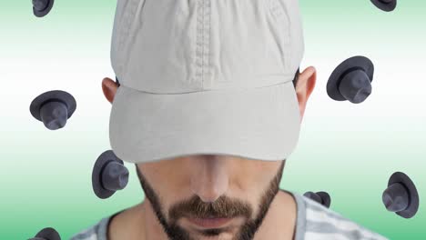 animation of caucasian man with cap over falling hats on white background