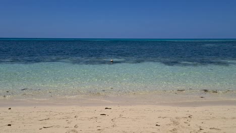 Lufttiefflug-über-Sandstrand-In-Richtung-Gelber-Boje,-Die-In-Der-Nähe-In-Gewässern-Schwimmt