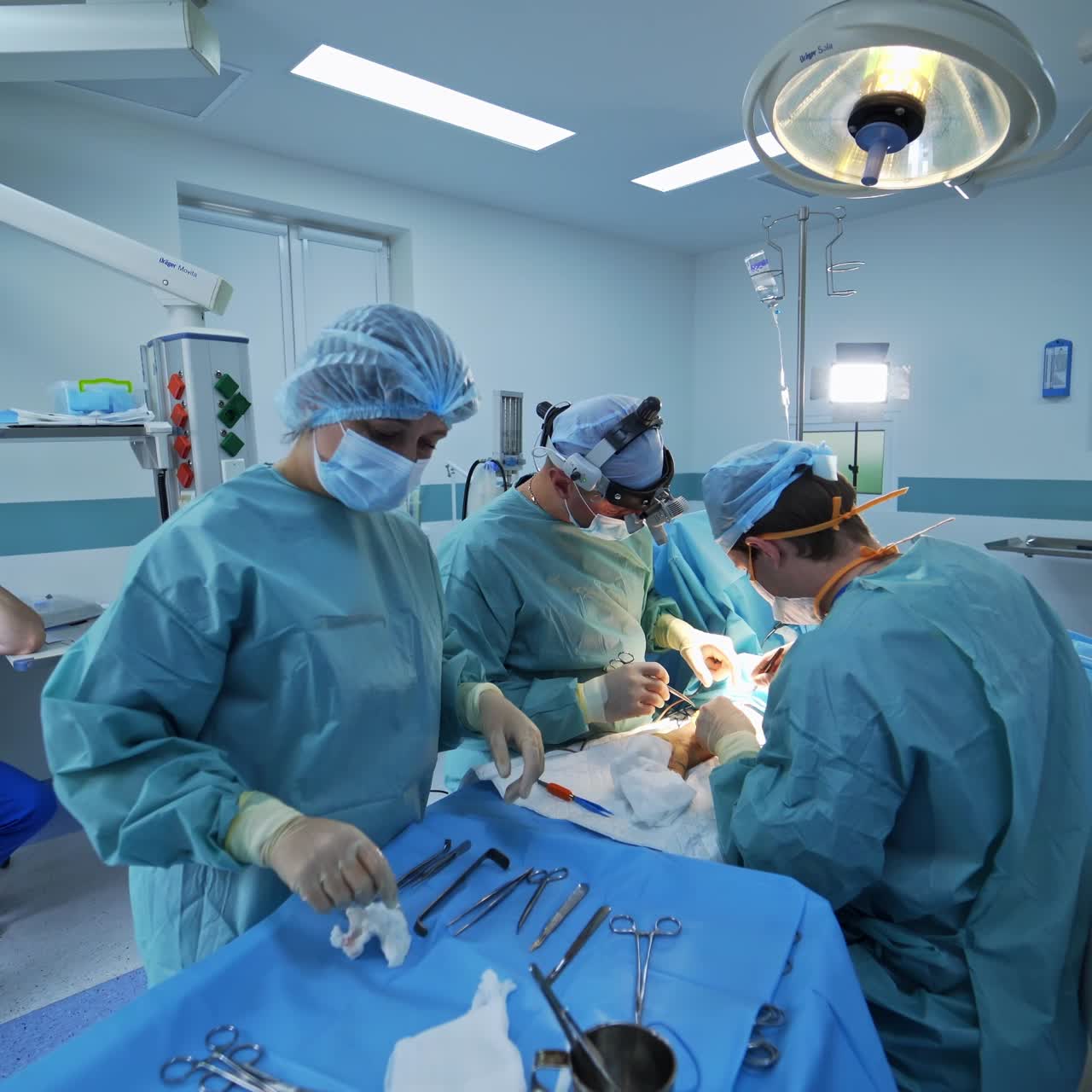 Surgery specialists operating patient's arm. Nurse preparing instruments and materials for doctor's usage