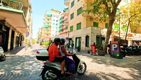 scooters and cars navigate a busy naples street