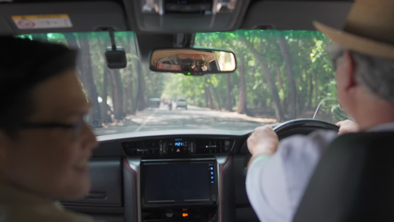 4k 아시아 고령 남자가 해변 로드 트립에서 가족과 이야기하면서 차를 운전합니다.