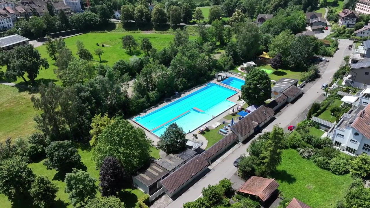 Forladt swimmingpool i grønne omgivelser, boligområde i byen. Droneudsigt