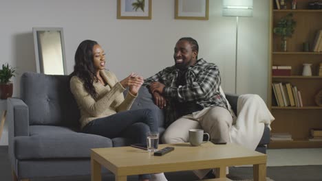 young couple relaxing at home sitting on sofa talking together 7