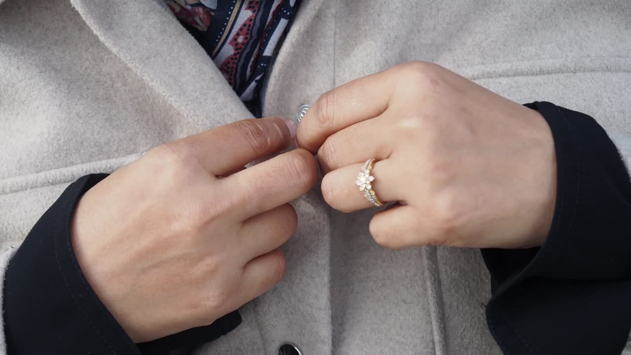 Woman buttoning a coat