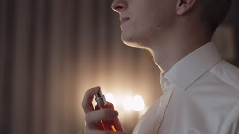 el novio se coloca perfume o desodorante en sí mismo, día de la boda, cámara lenta, hombre de negocios bien vestido