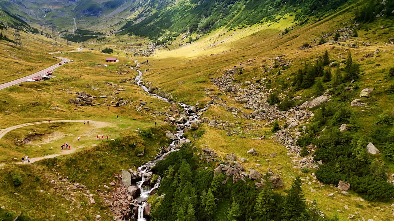 Transfagarasan road with parking area in the valley. Cars parked near the serpentine section of the Transfagarasan highway surrounded by mountains
