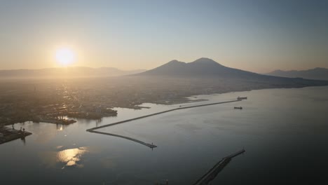 aerial hyperlapse rotating around the naples harbor with the sunrise and mount vesuvius in the background.
