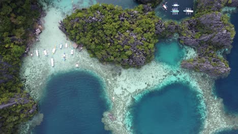 blue holes and clear water amid lush karst outcrops at twin lagoon, coron