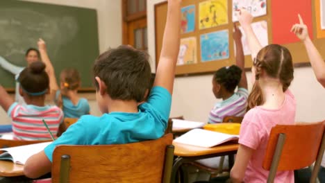 niños del aula levantando las manos