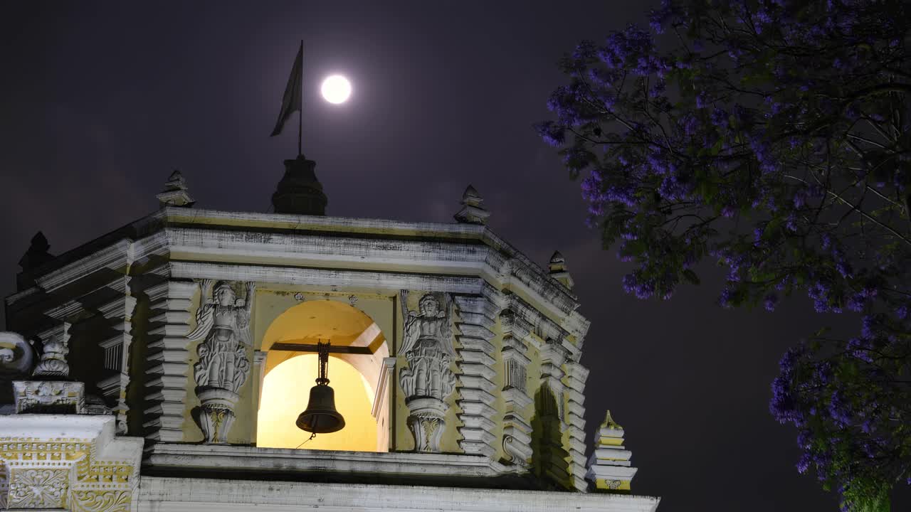 el timelapse captura el viaje de la luna a través del cielo nocturno, perfectamente enmarcado por el icónico campanario de la iglesia de la merced.
