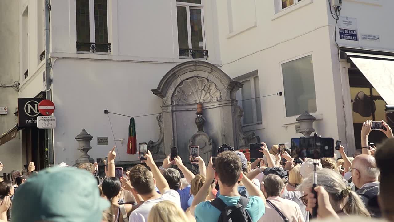 People in the city center of Brussels taking pictures of Manneke pis while they changed the costume.