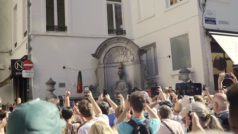 people in the city center of brussels taking pictures of manneke pis while they changed the costume.