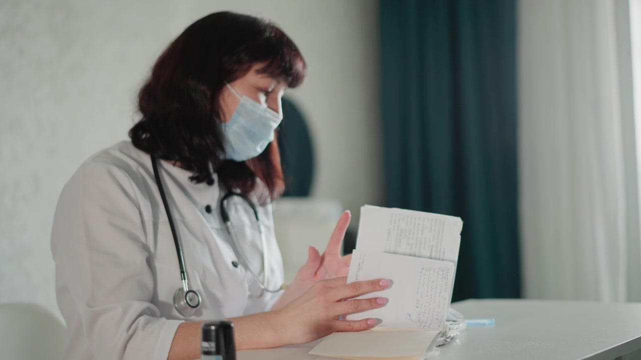 Especialista en atención médica inspecciona cuidadosamente los documentos de admisión durante la consulta. Proveedor de atención médica verifica meticulosamente la documentación del paciente en un entorno tranquilo con un estetoscopio cerca