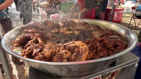 cooking pork stew at a street market.