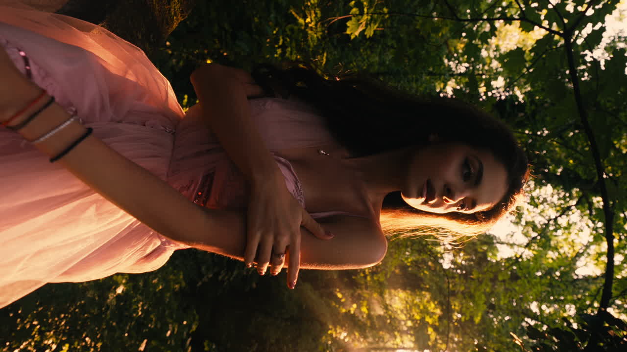 Young Beautiful Brunette Woman Wearing Pink Wedding Dress, Sensual Pose, Backlight Natural Sunlight, Golden Hour, Mystical, Forest Background, Slow Motion Track in In, Portrait, vertical