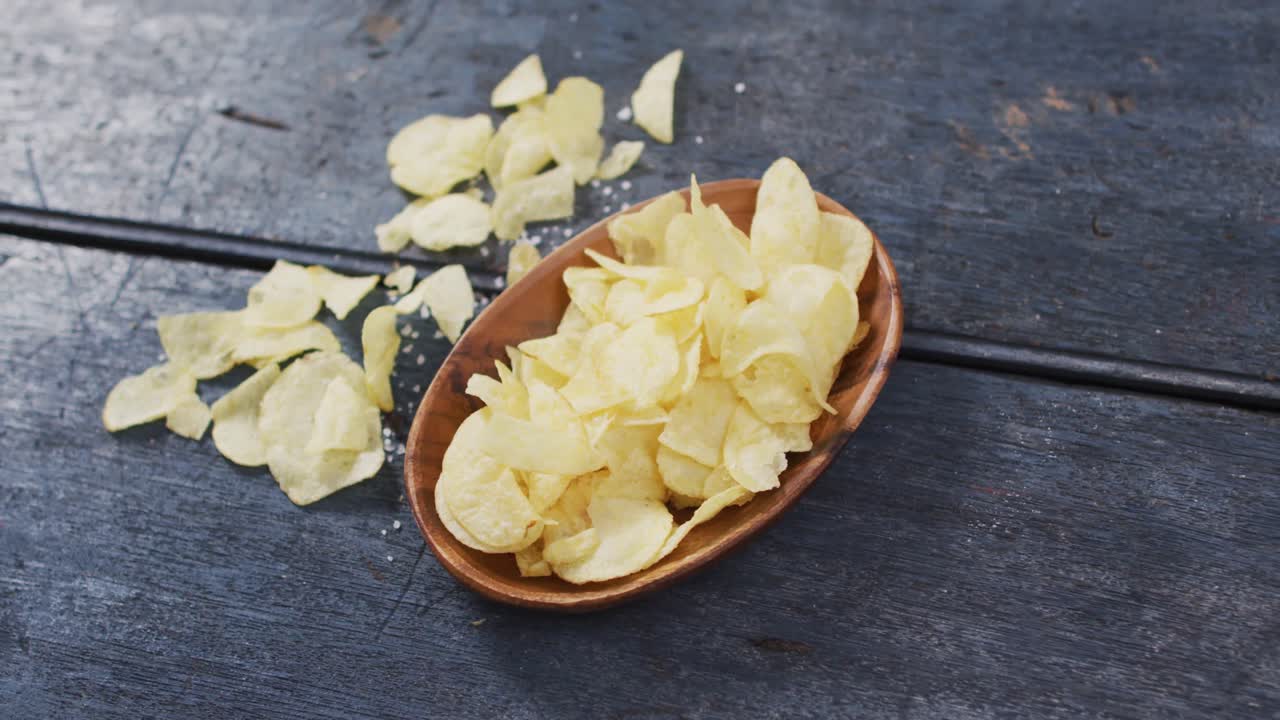 Close up view of potato chips in a bowl with copy space on wooden surface