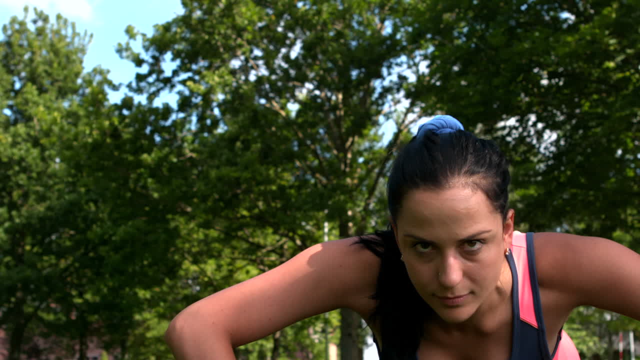 bruneta en forma haciendo push up en el parque