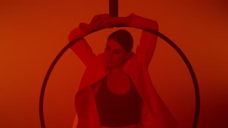 woman performing aerial hoop in red light