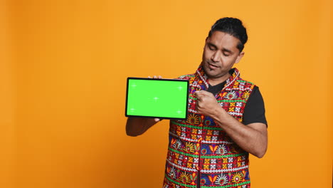 portrait of man doing influencer marketing using green screen tablet