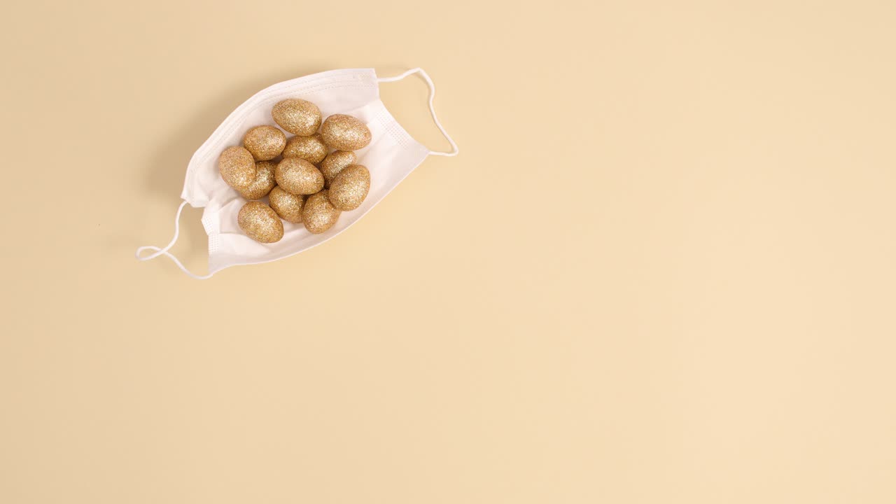 Uova di Pasqua dorate di design si muovono con mascherina su sfondo luminoso. Stop motion