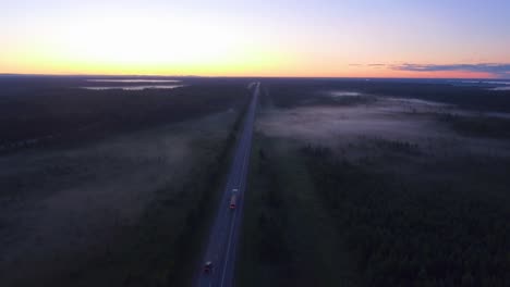 foggy morning drone shot over the highway with a transport truck driving eastbound