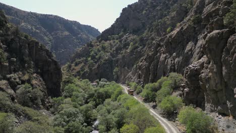 Rugged-rock-canyon-aerial-meets-heavy-dump-truck-on-narrow-dirt-road