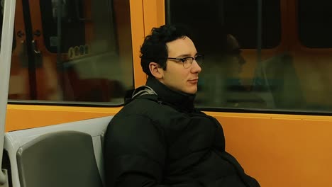 man resting by the window in a subway train in vienna, austria