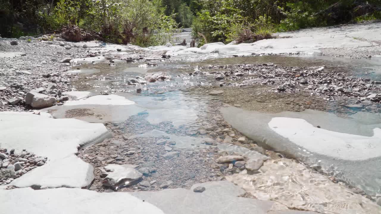 mujer montando su bicicleta de montaña a través de un arroyo en un día soleado de verano
