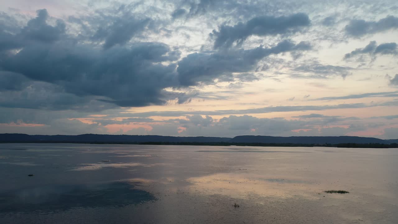 극적인 구름으로 조용한 호수 위에 해가 지는 것