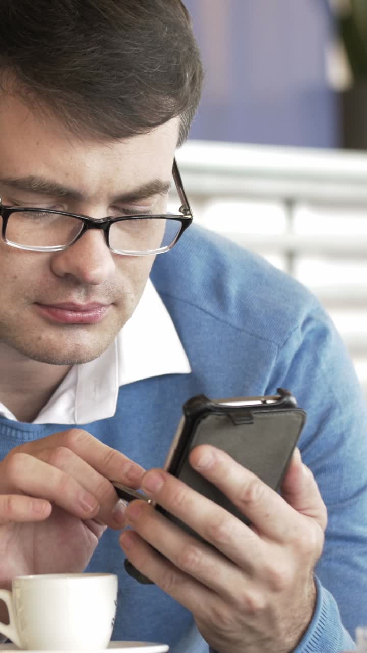 hombre usando teléfono inteligente con café