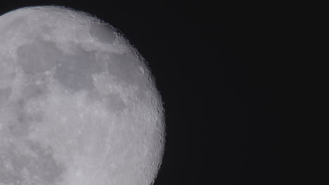 close up view of the full moon against pitch black space