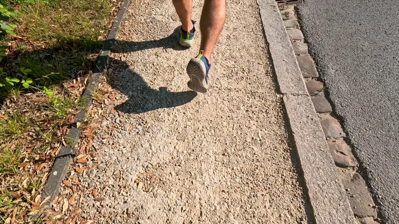 persona caminando por un camino de adoquines iluminado por el sol