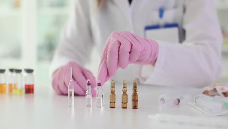 scientist handling medical ampoules in a laboratory