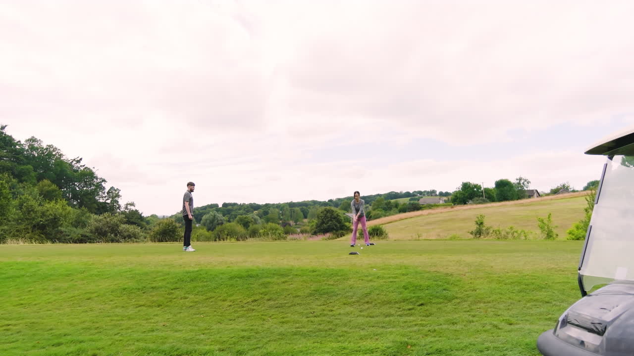 Golf players playing golf together, hitting the ball with club on a golf course, copy space