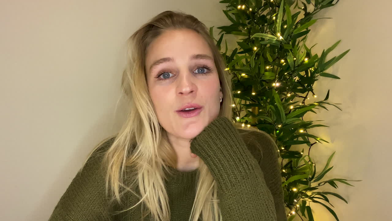 mujer joven en videollamada que parece visiblemente deprimida mientras habla con el terapeuta