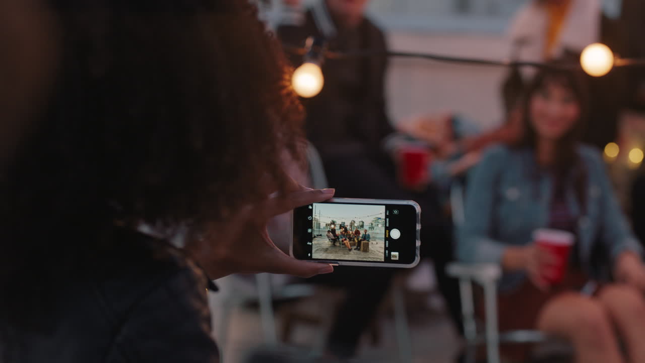 해가 지는 지붕 파티에서 사진을 찍기 위해 포즈를 취하는 다민족 친구 그룹 학생들이 도시에서 주말 모임을 즐기고 있습니다.