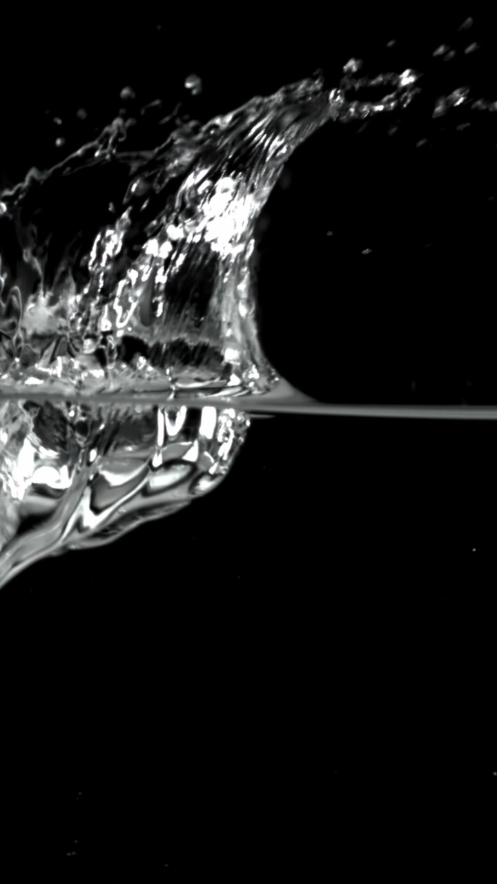 Versamento e schizzi dinamici dell'acqua con bolle su sfondo nero
