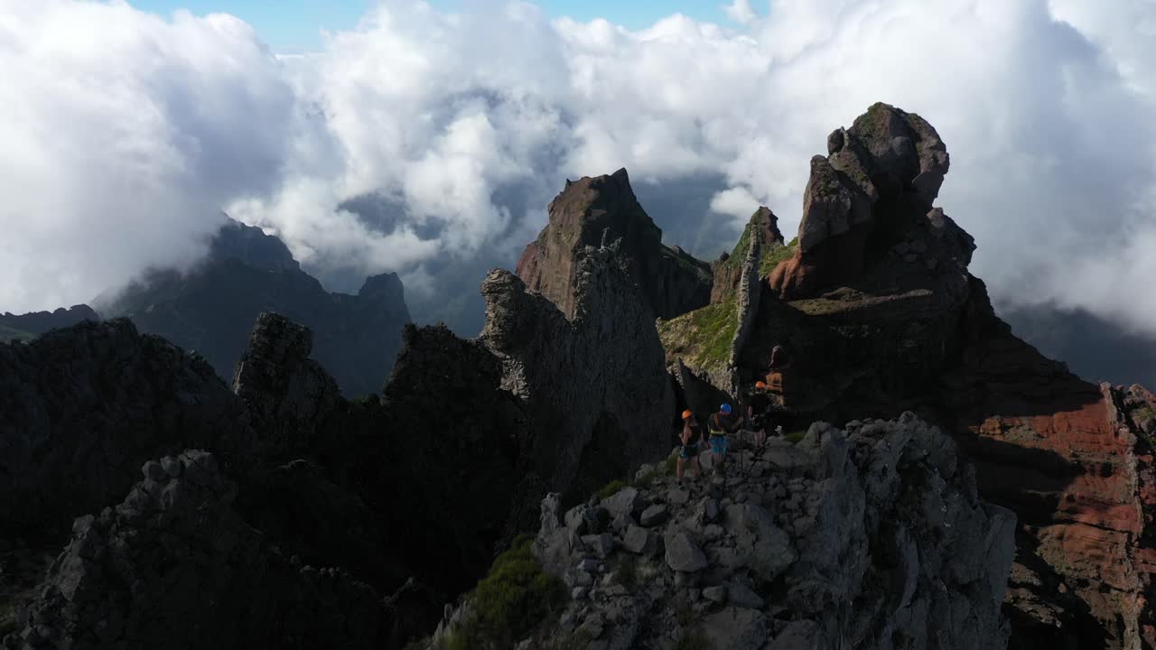Rising drone shot of a group of 3 friends on top of Pico das Torres in Madeira.