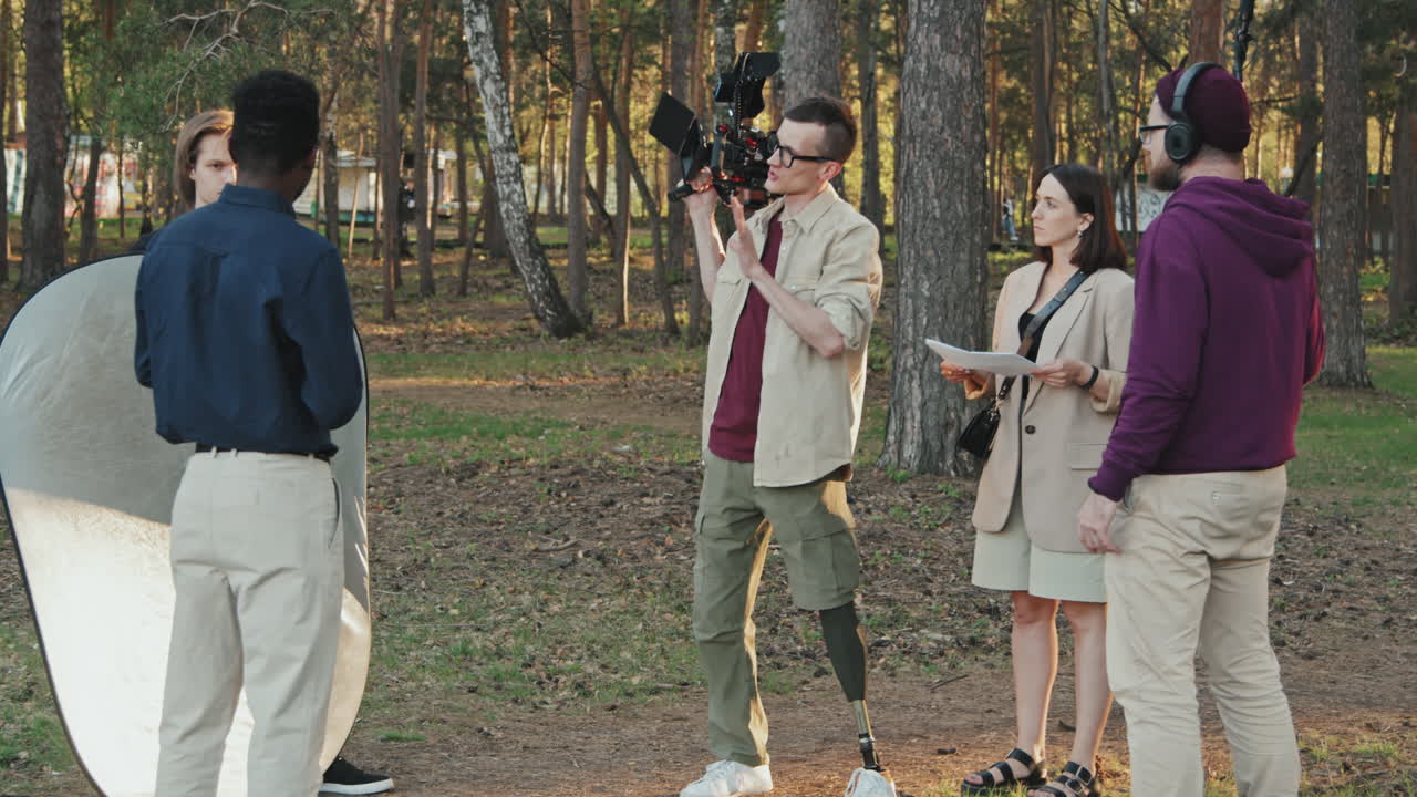 Cameraman With Leg Prosthesis Talking To His Filming Crew