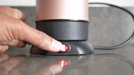 hand turning on a portable coffee maker