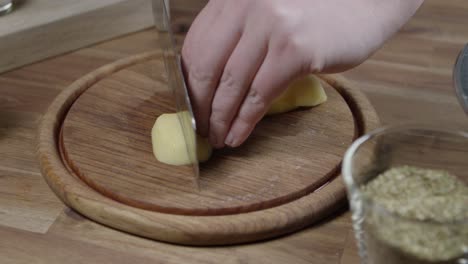 el chef corta las papas crudas en rayas.