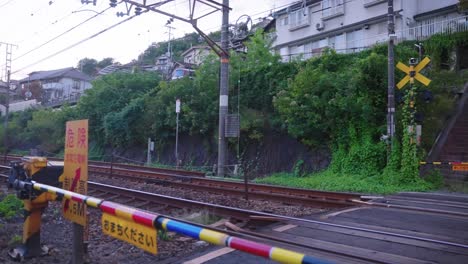 slow motion shot as a train passes a rural crossing in small port town on the inland sea of japan