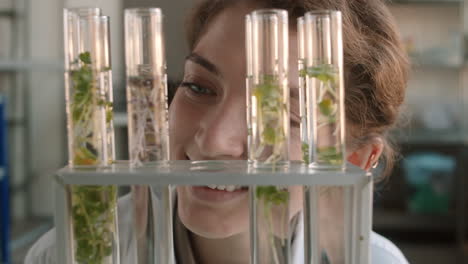 mujer científica examinando plantas en crecimiento en tubos de ensayo