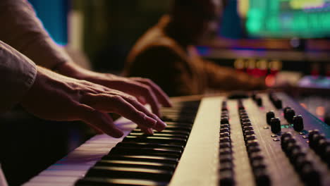 musician composer playing midi controller synthesizer in professional studio