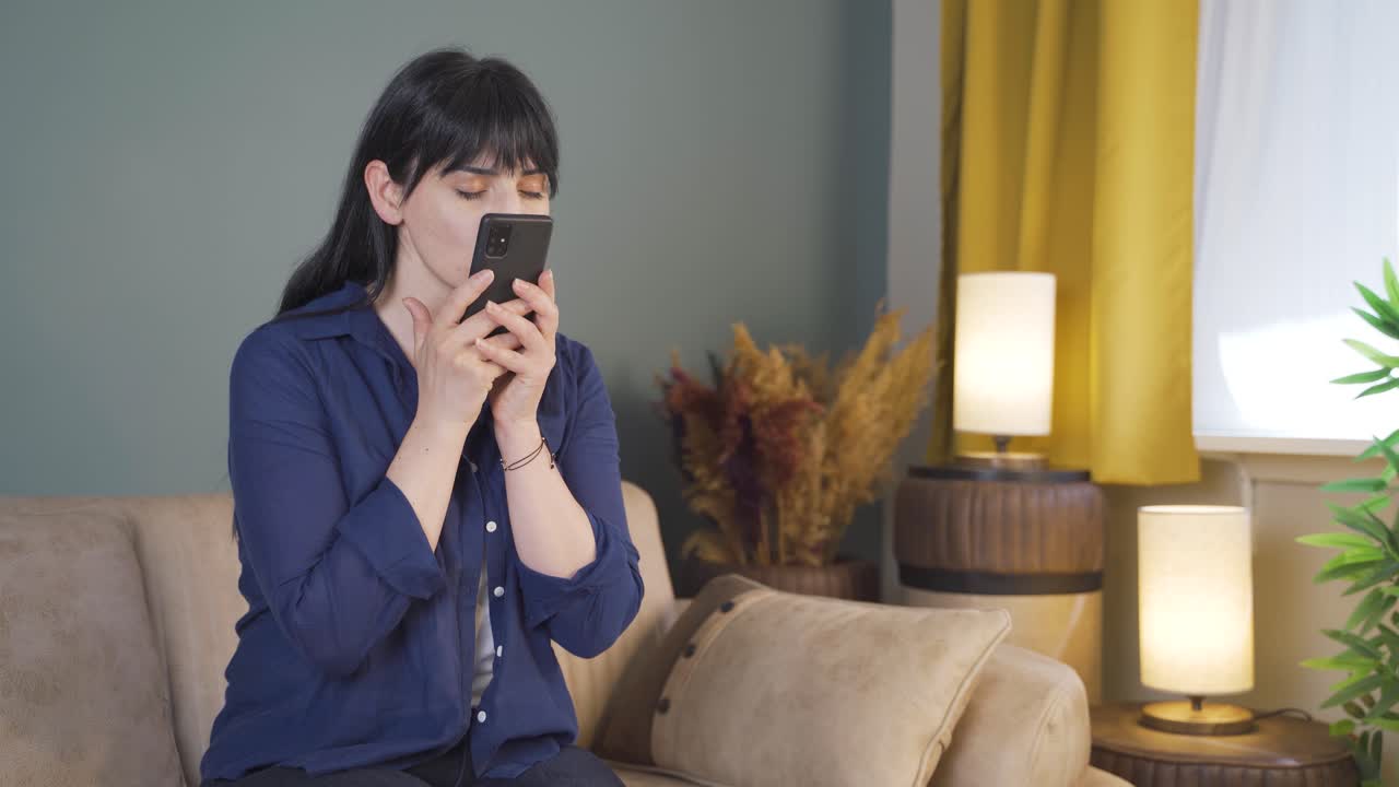 그리움으로, 그 여자는 휴대폰에 있는 사진을 쳐다본다.